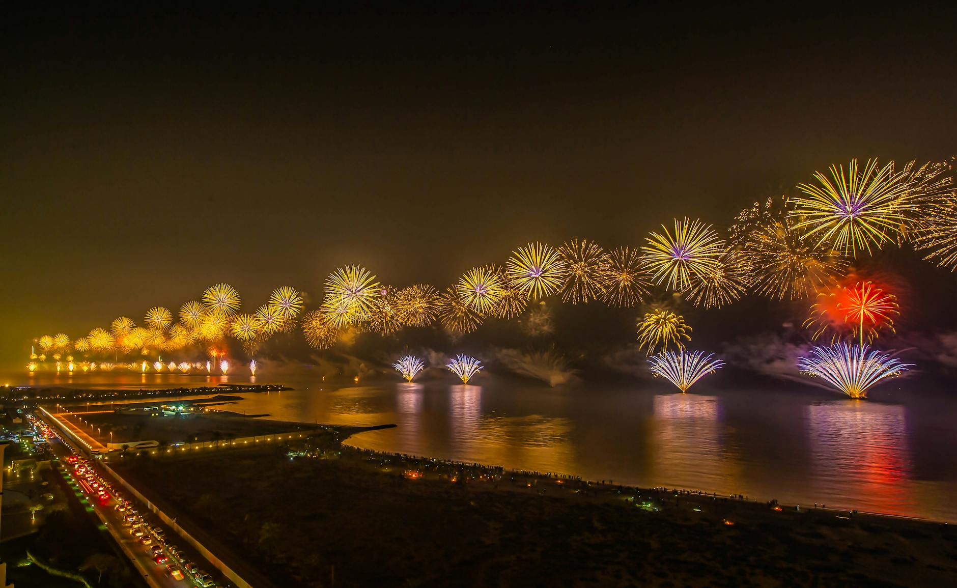 Vibrant fireworks display lighting up the night sky over Ras Al-Khaimah waterfront during a festive celebration.