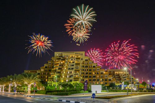 Free Vibrant fireworks illuminate the Ras Al-Khaimah cityscape, celebrating a festive night. Stock Photo