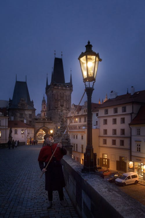 Lamplighter Lighting a Lantern during Advent Time at the Charles Bridge in Prague, Czech Republic