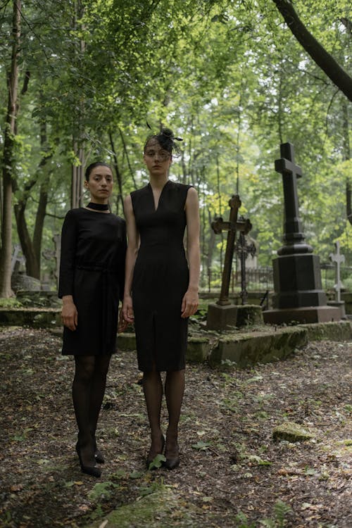 Women in Black Dresses Standing in Graveyard