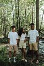 Three Teenagers Standing Together in Forest During Summer Vacation