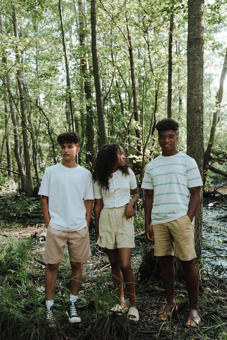 Three Teenagers Standing Together In Forest During Summer Vacation