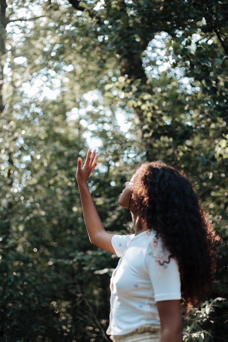 Portrait Of Teenage Girl In Forest Reaching Her Hand Up