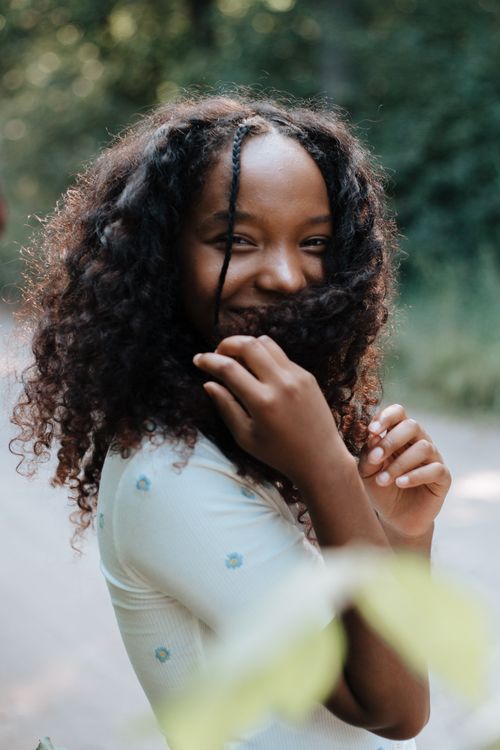 Free Smiling teenage girl in a forest, enjoying a summer day with playful expressions. Stock Photo