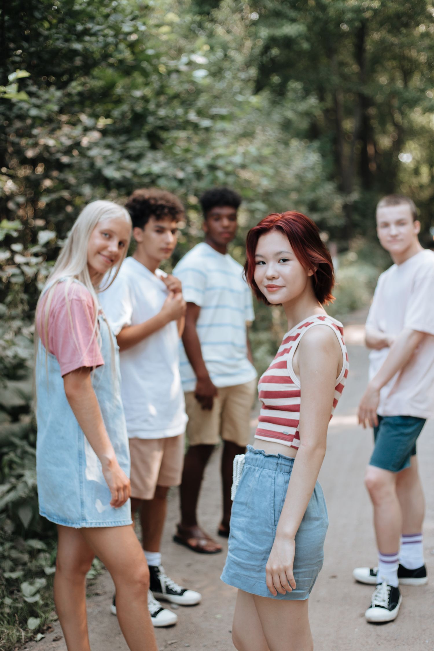 A diverse group of teenagers on a summer outdoor trip in a forest