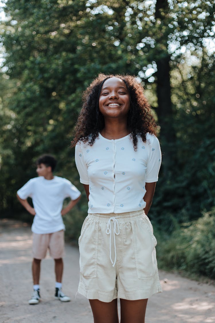 Smiling Teenage Girl In White T-shirt And Beige Shorts