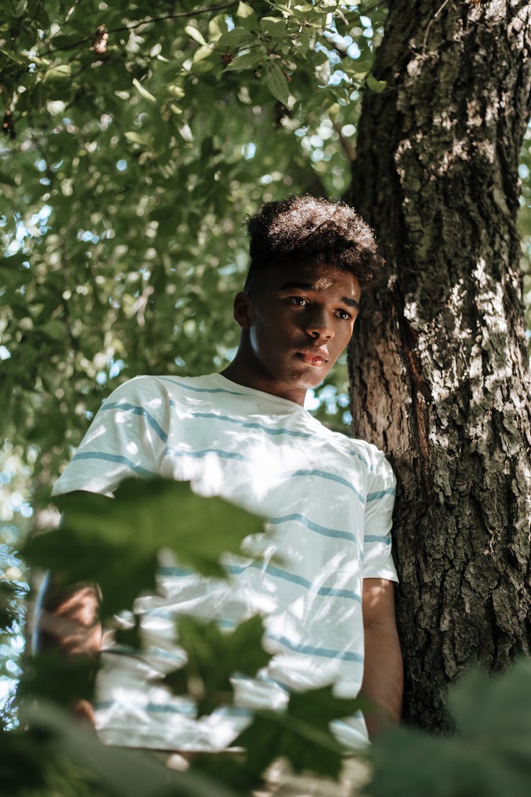 Teenage Boy Standing Under Tree