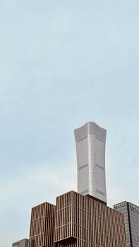 Tall modern skyscraper with unique design set against a clear blue sky.