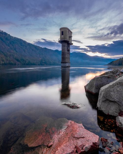 Free Peaceful dusk over Divnogorsk's reservoir with a tower, reflecting serene skies. Stock Photo