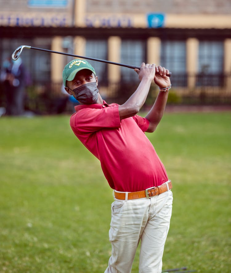 A Man In Red Polo Shirt Holding A Golf Club