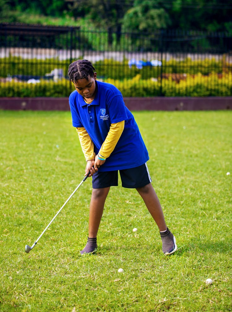 Boy In Blue Polo Shirt Playing Golf