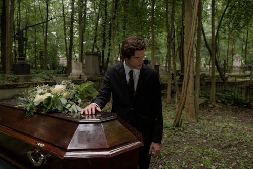 Man in Black Suit Standing near the Coffin