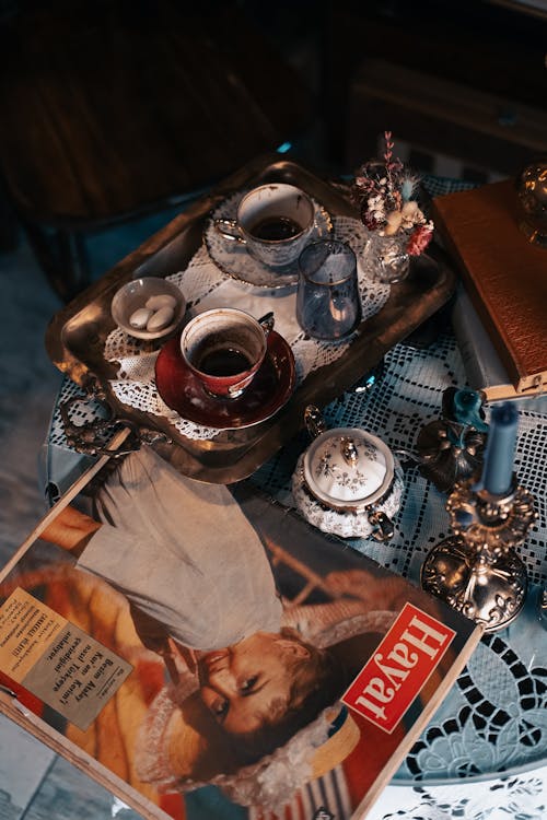 Overhead Shot of a Magazine beside a Tea Set
