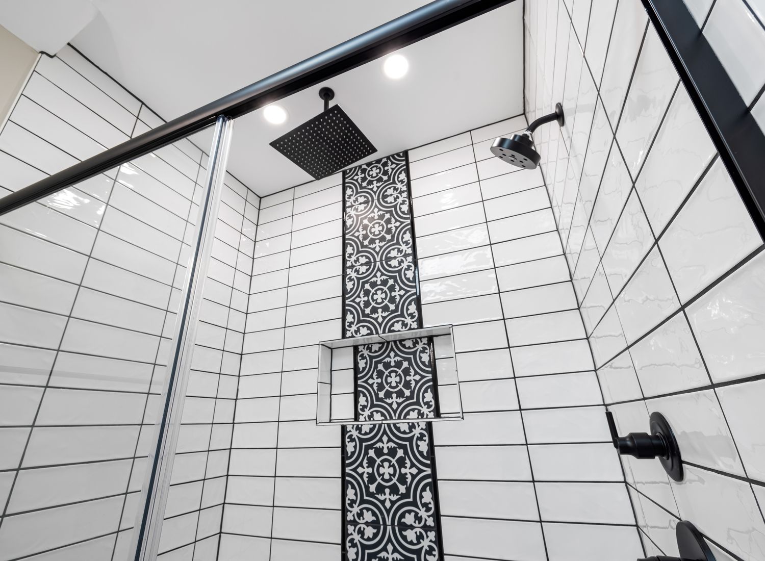 Black shower head and shower controls installed on finished tile