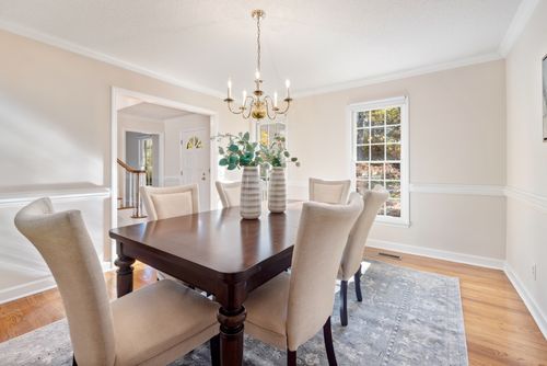 Free A minimalist dining room with elegant design, featuring a wooden table and modern chandelier. Stock Photo