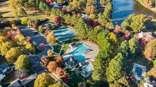 Free Aerial shot of a vibrant community park with tennis courts, swimming pool, and lush trees in Raleigh, NC. Stock Photo