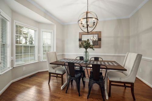 Free Elegant dining room with modern decor, featuring a minimalist table setting and a stylish chandelier. Stock Photo
