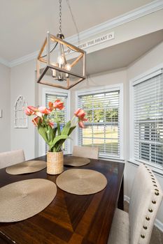 Bright dining area with a wooden table and elegant tulip arrangement.