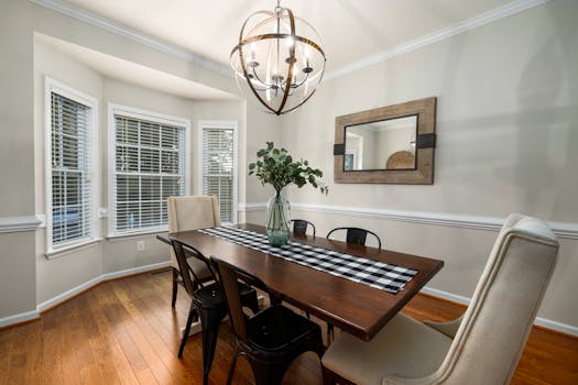 Elegant dining room setup featuring a wooden table and modern chandelier.