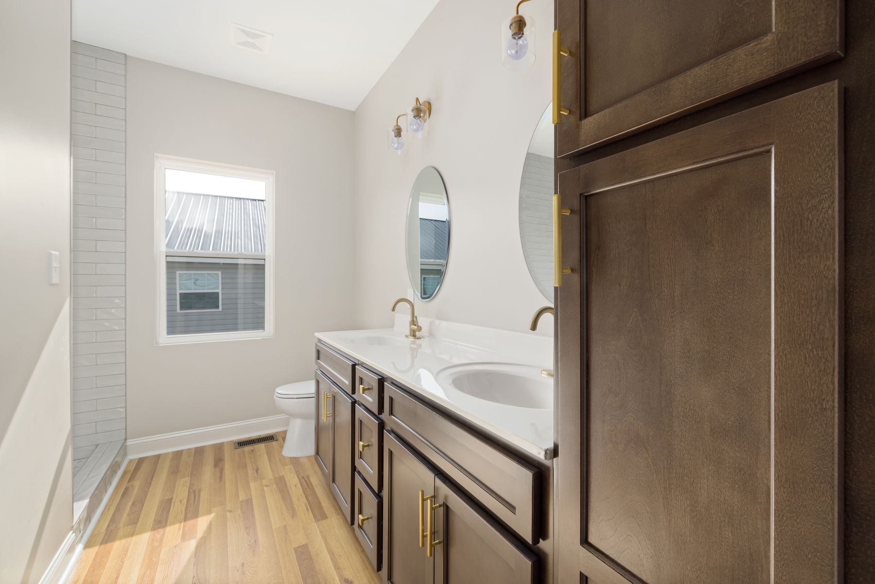 Bright bathroom with wooden vanity, natural light and small-format geometric tile