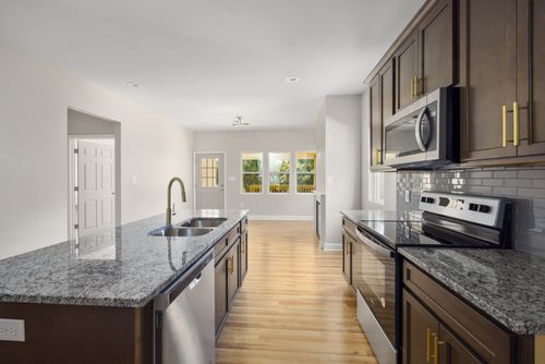 Free Bright and modern kitchen featuring granite countertops and stainless steel appliances for a sleek look. Stock Photo