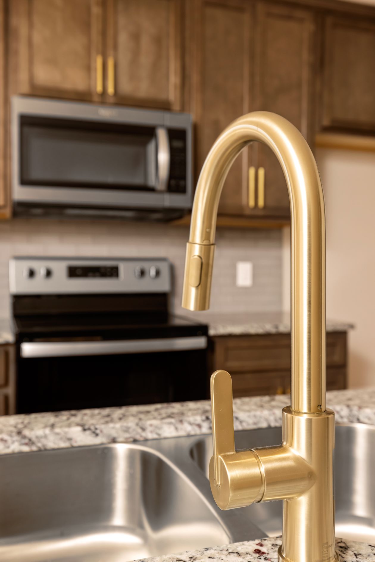 Brass faucet close-up over a stainless steel sink