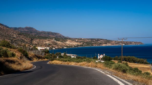 Beautiful coastal road with mountain range and ocean in the background.