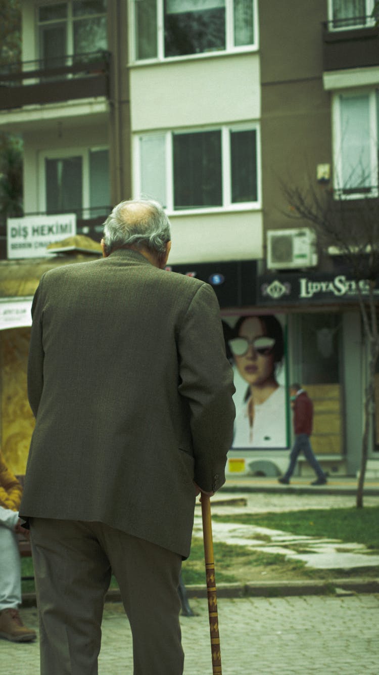 Old Man With Walking Stick On Street