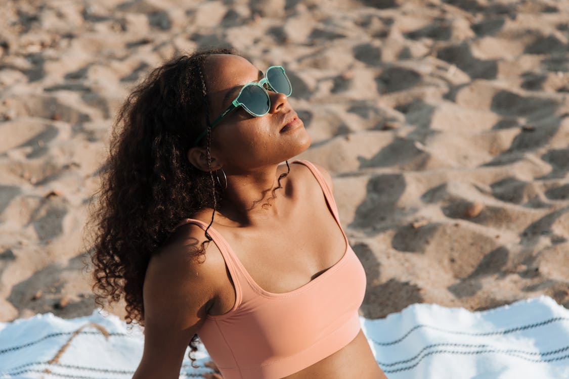 Woman Sitting on Towel and Sunbathing