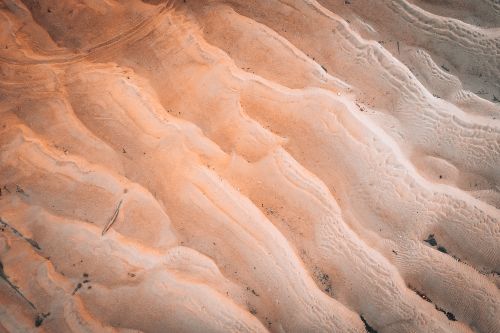 Free Aerial capture of abstract sand patterns creating wave-like textures in a desert setting. Stock Photo