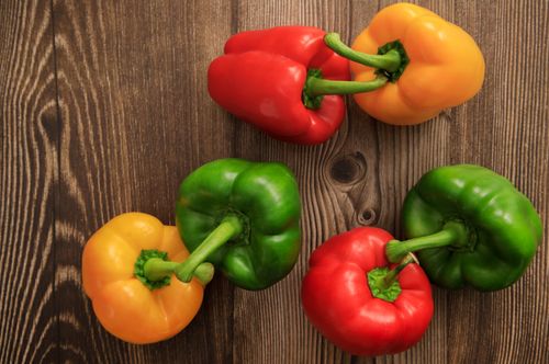 Free Colorful bell peppers arranged on a wooden surface, showcasing freshness and organic appeal. Stock Photo