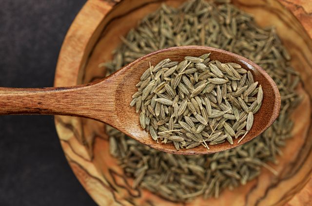 Bold cumin seeds presented on a wooden spoon
