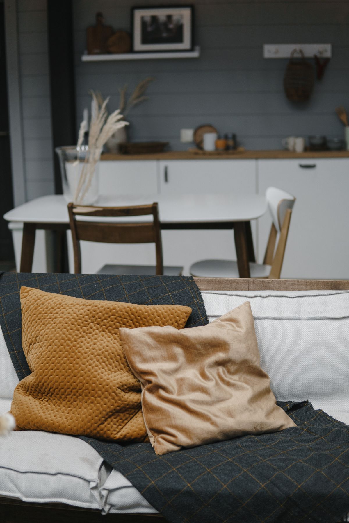 A styled living scene — mustard and beige pillows on a neutral sofa.