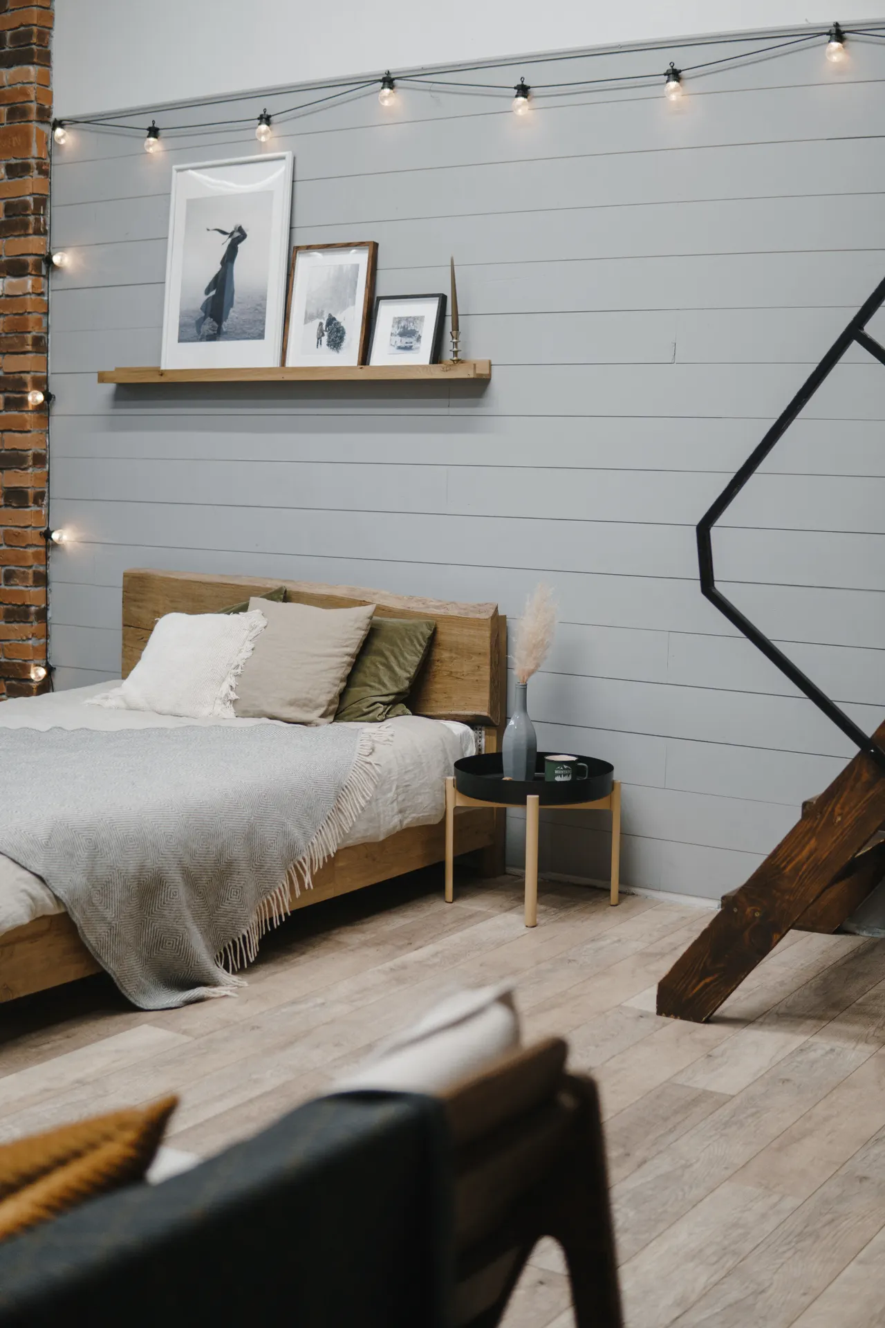 floating-shelf-above-vanity-storage Bedroom wall with floating picture ledge shelf and string lights above the bed