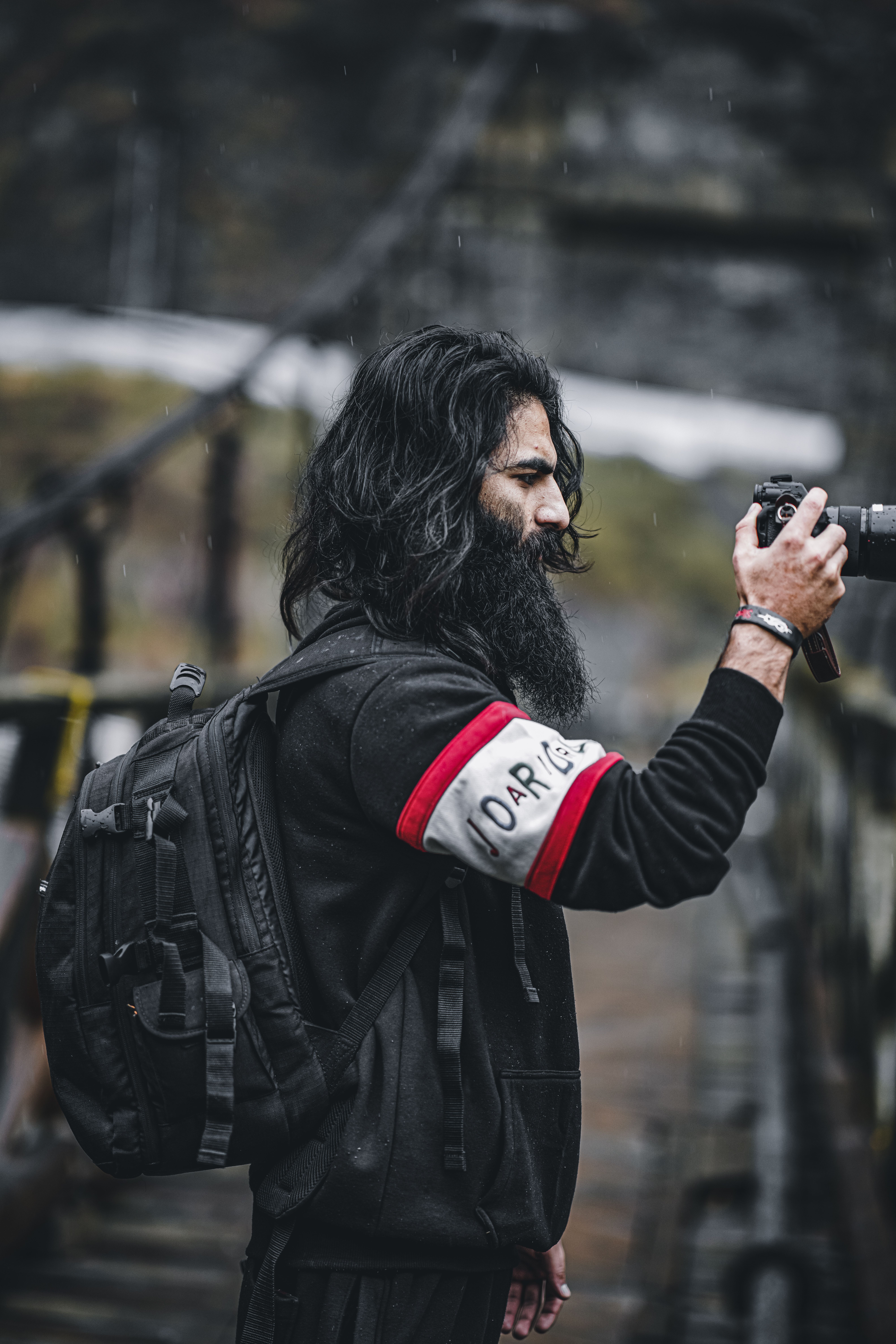 Side view of a man with a camera capturing picturesque outdoor scenery. Ideal for travel and photography themes.
