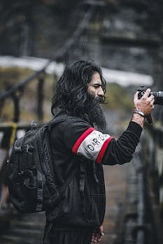 Side view of a man with a camera capturing picturesque outdoor scenery. Ideal for travel and photography themes.