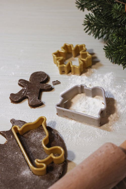 A Brown Dough with Cookie Cutters on a Surface with Flour