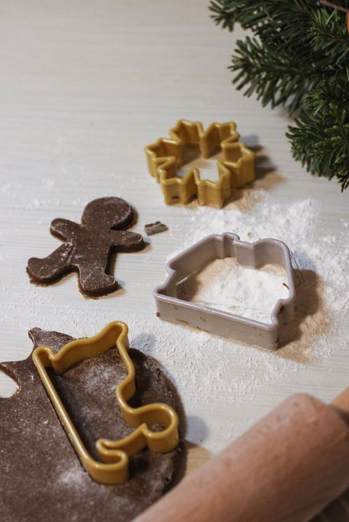 Free Gingerbread dough with festive cookie cutters ready for baking holiday treats. Stock Photo