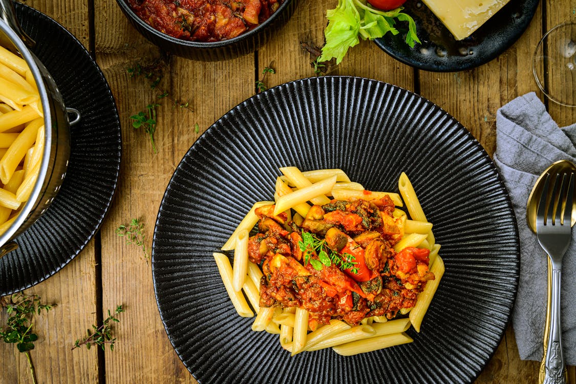 Penne Pasta with Red Sauce on Black Round Plate