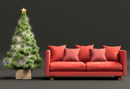 Free Elegant Christmas setup featuring a red sofa and decorated tree, perfect for holiday interior inspiration. Stock Photo