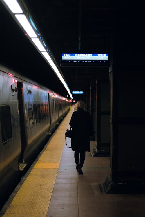 Woman Wearing Black Coat Walking on Train Station
