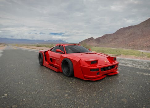 High-performance red sports car cruising on an open road with dramatic landscape.