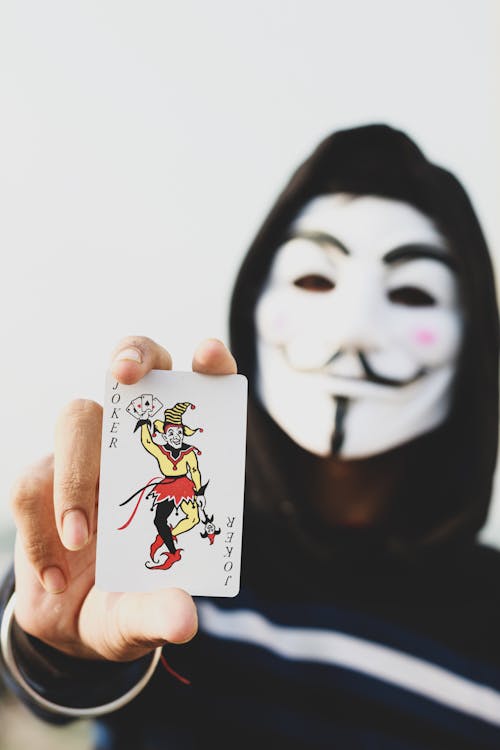Free Person Holding Joker Playing Card Stock Photo