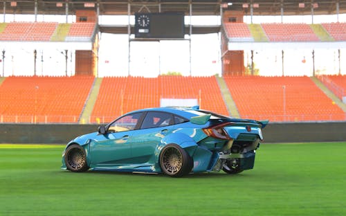 Blue Car on Green Grass Field of Football Stadium