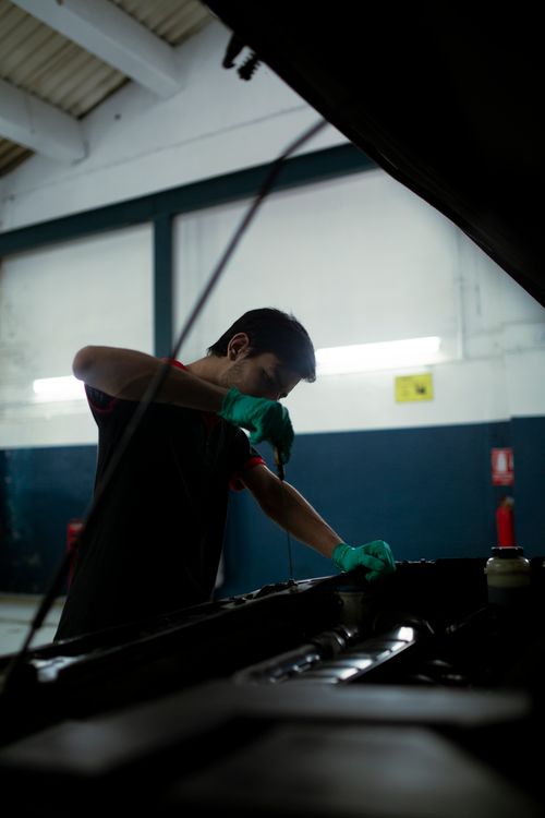 Un meccanico controlla l’olio del motore durante la manutenzione ordinaria