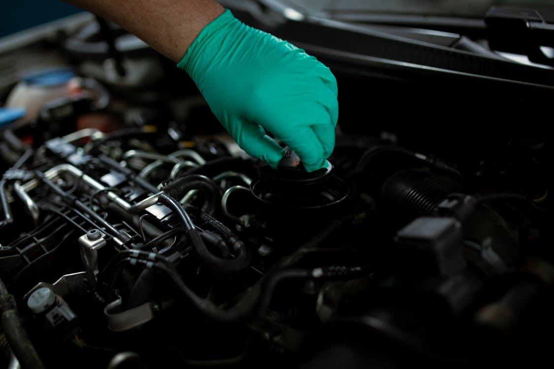 Free A Mechanic Opening the Oil Filler Cap of a Car Engine Stock Photo