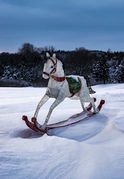 A nostalgic winter setting featuring a decorative rocking horse amidst snowy landscapes.