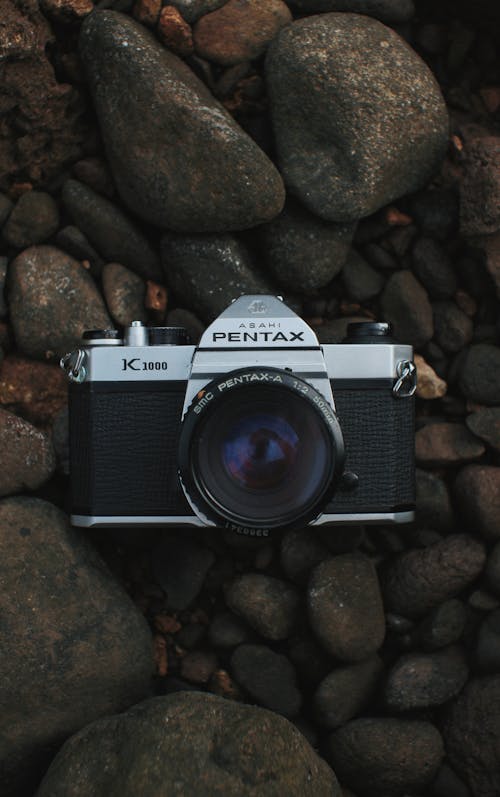 Free Close-Up Shot of a Black Camera on top of Rocks Stock Photo