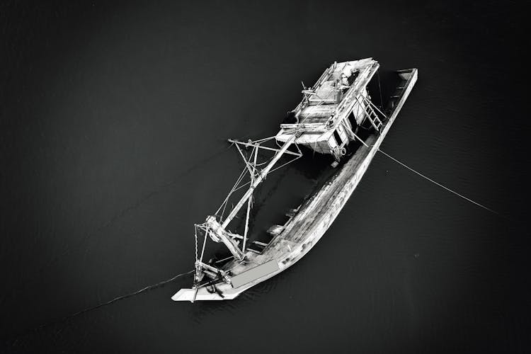 A Grayscale Of A Sinking Boat