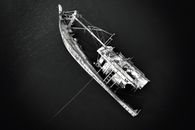 Grayscale Photo of a Tilted Boat on a Body of Water